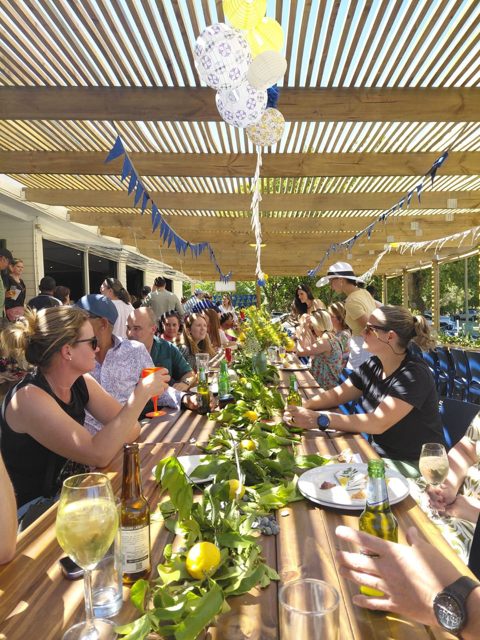 Guests seated at a long patio table